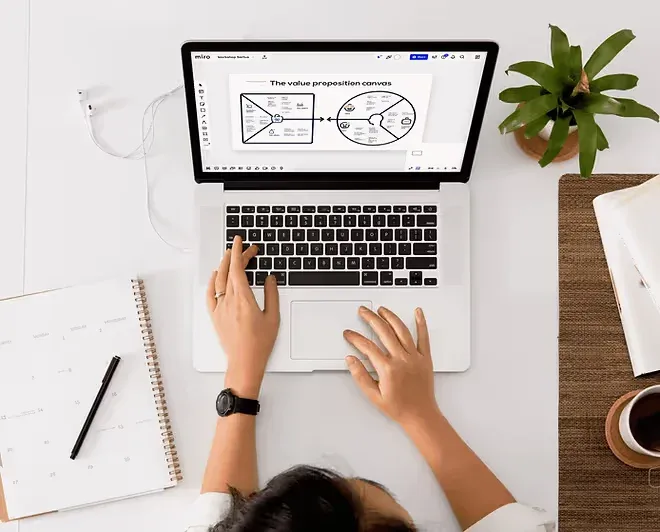 Someone at a laptop with a value proposition canvas on screen